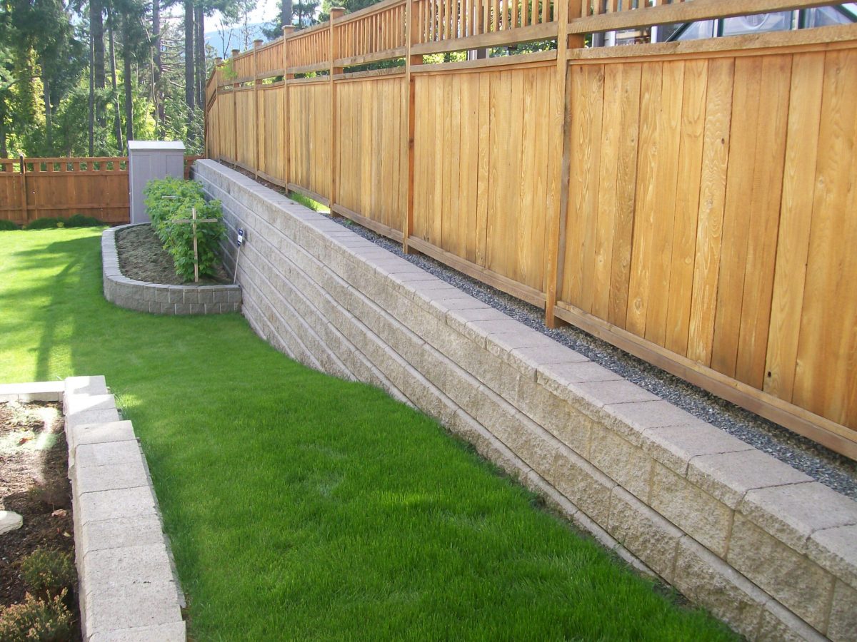 block retaining wall with wood fence and stone planters